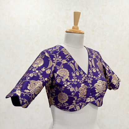Purple floral blouse on a mannequin against a white background